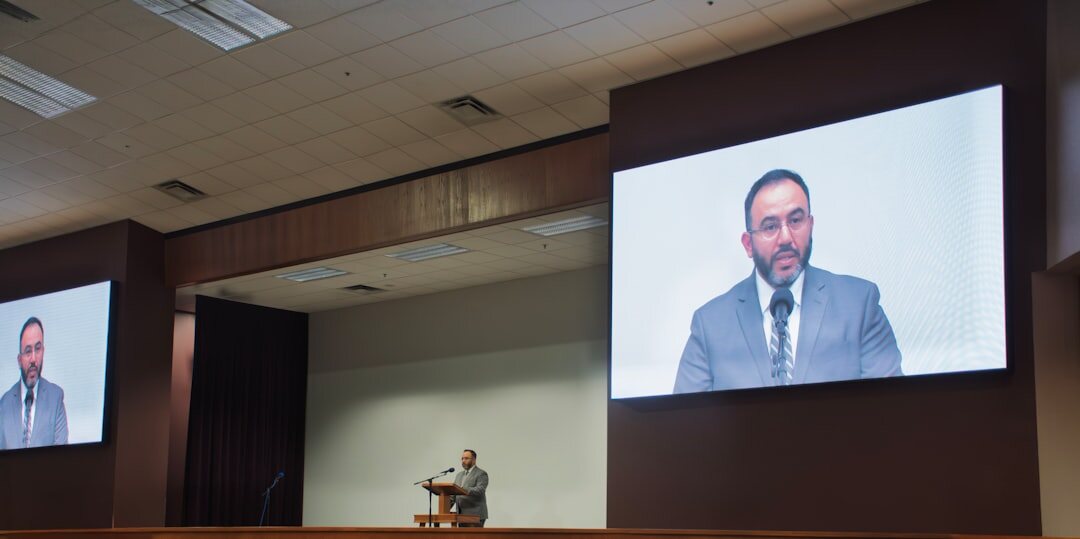 Professional speaker presenting at a business conference podium